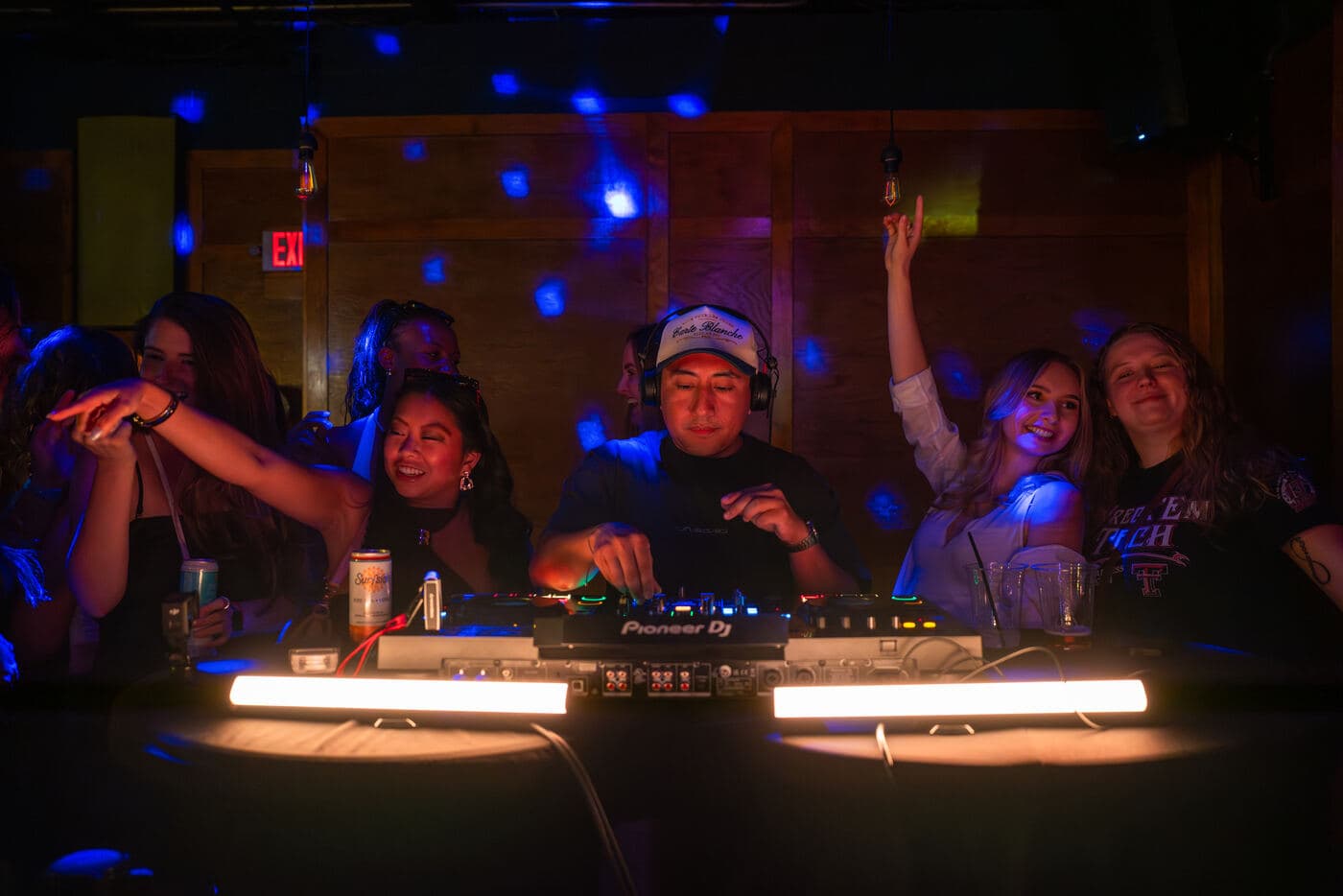 LP DJing with the crowd cheering under blue disco lighting